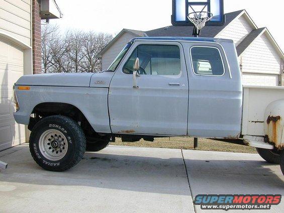 Gray pickup truck, side view, showing rust spots and a basketball hoop mounted above the cab