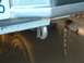 1990 Ford Bronco - A close-up view of a vehicle's rear bumper, tow hook, and exhaust pipe.