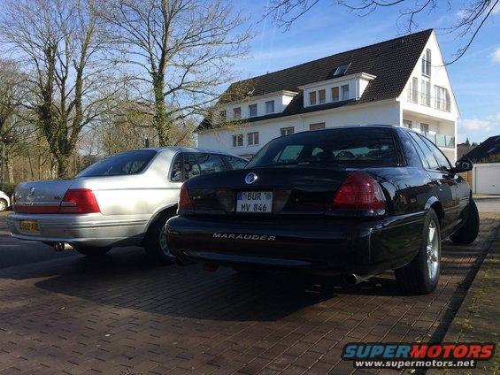 Black Mercury Marauder and silver sedan parked on brick driveway