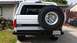 1992 Ford Bronco - Rear view of a white 1992 Ford Bronco, showing its spare tire and California license plate.