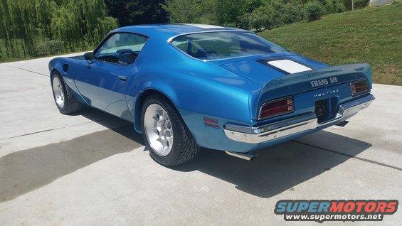 Blue 1970 Pontiac Trans Am with white stripe on rear deck, viewed from rear-left