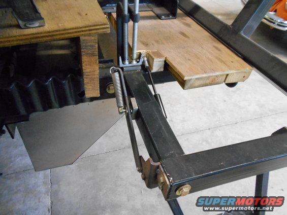 Vehicle lift mechanism with wooden platform and spring