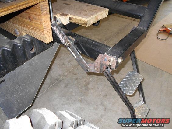 Close-up of a trailer hitch mechanism with diamond plate steps and wooden supports