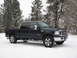 2007 Ford F-250 - A dark blue 2007 Ford F-250 Lariat pickup truck is parked in the snow with trees in the background.
