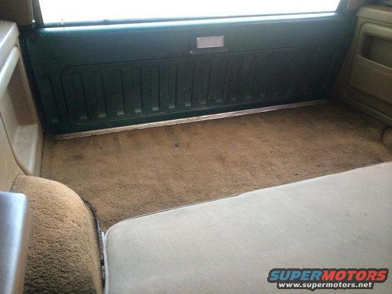Interior cargo area with brown carpet and green paneling