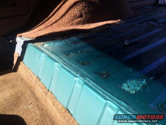 Interior cargo area floor with brown carpet and teal plastic trim