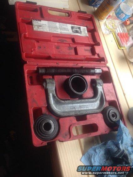 Red case with ball joint press tool and assorted cups. Blue shop rag nearby