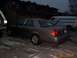 2003 Ford Crown Victoria - A 2003 Ford Crown Victoria is parked next to a white van.