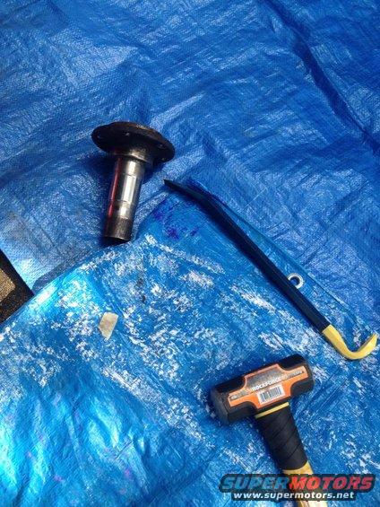 Automotive part and tools on blue tarp