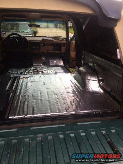 1990 Ford Bronco interior with sound deadening on floor and cargo area, dashboard visible