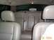 2003 Ford Crown Victoria - Interior view of tan leather rear car seats and headrests, showing a seatbelt and the car's interior lighting.