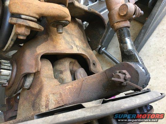 Rusted suspension parts with visible nuts and bolts, close-up