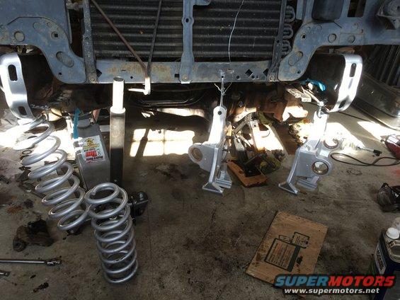 Vehicle front suspension disassembled with springs and suspension components on the ground