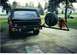 1988 Ford Bronco - The rear of a black Ford Bronco is shown with a spare tire and gas can mounted on a custom carrier.