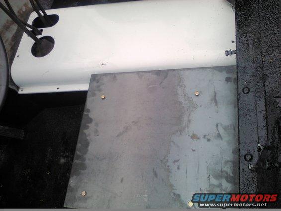 Interior floor panel with metal plate and white component with two circular openings