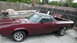 1972 Ford Ranchero - A maroon 1972 Ford Ranchero with a black vinyl top sits in a driveway next to a boat.