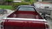 1972 Ford Ranchero - Rear view of a maroon pickup truck with a white stripe on the tailgate, parked in a driveway.