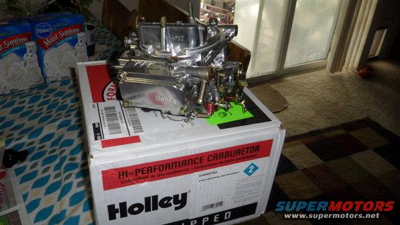 Chrome Holley carburetor sits on a white box labeled "HI-PERFORMANCE CARBURETOR"