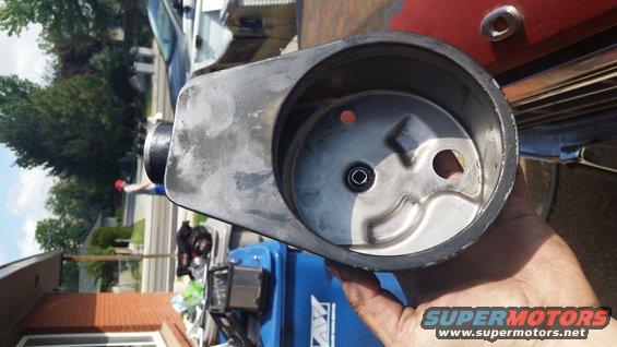 Hand holding a power steering pump housing with internal vanes visible