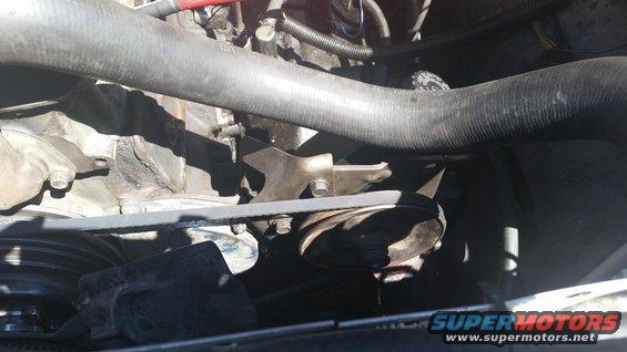 Close-up of engine bay showing hoses, belts, and pulleys