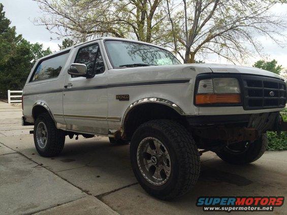 White 1995 Ford Bronco parked on driveway, front quarter view