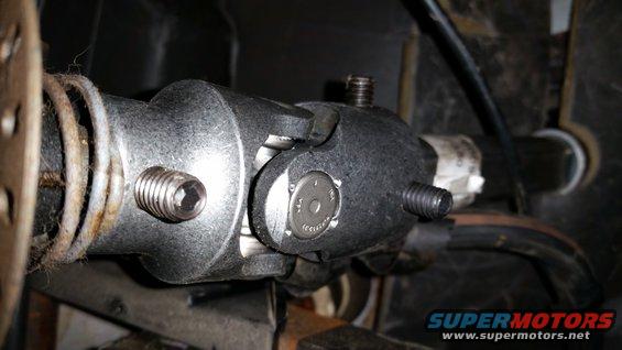 Steering shaft universal joint with hex bolts and a circular metal tag