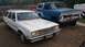1980 Ford Fairmont - Two vehicles are parked outdoors: a white 1980 Ford Fairmont station wagon and a blue pickup truck.