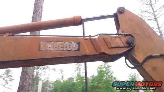 Excavator arm with KOBELCO logo and hydraulic cylinder