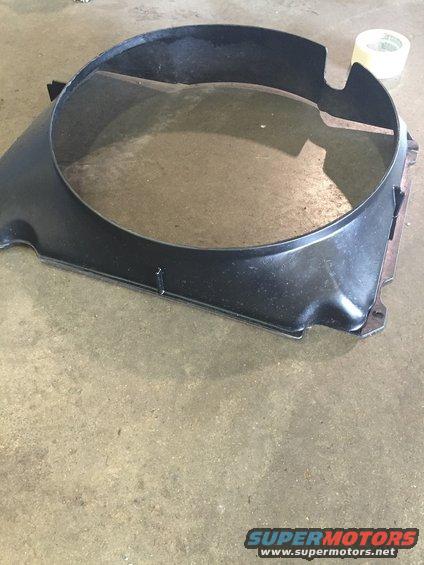 Black plastic radiator fan shroud with a circular opening