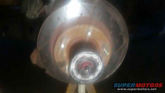 Close-up of a vehicle's front wheel hub assembly with a brake rotor visible