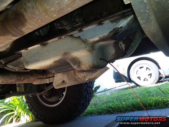 Transmission pan and exhaust pipe of a 1996 Ford Bronco, with a drip pan below