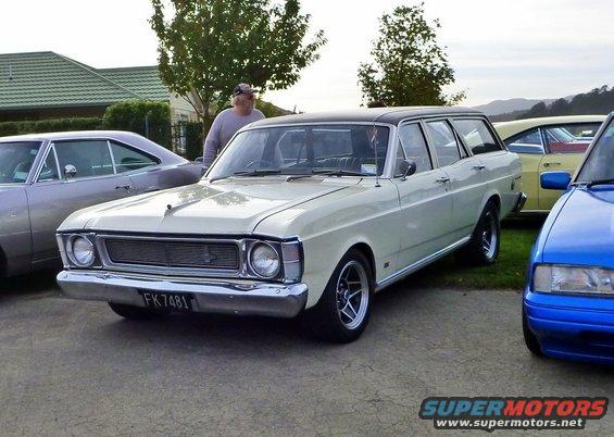 Cream station wagon with black roof, parked next to a silver coupe and a blue car. License plate FK 7481