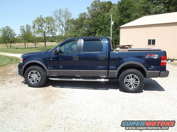 Dark blue Ford F-150 pickup truck with FX4 Off Road badging, chrome side steps, and aftermarket wheels