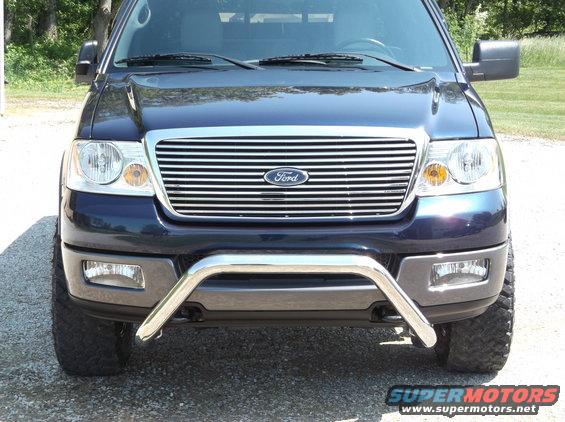 Dark blue Ford F-150 front grille with chrome bull bar. Headlights and fog lights visible