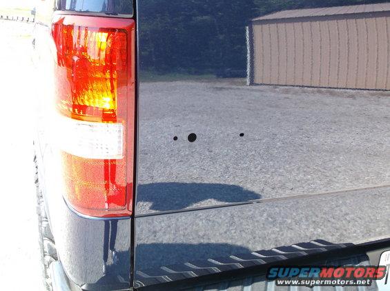 2004 Ford F-150 tailgate with two small holes drilled near the center