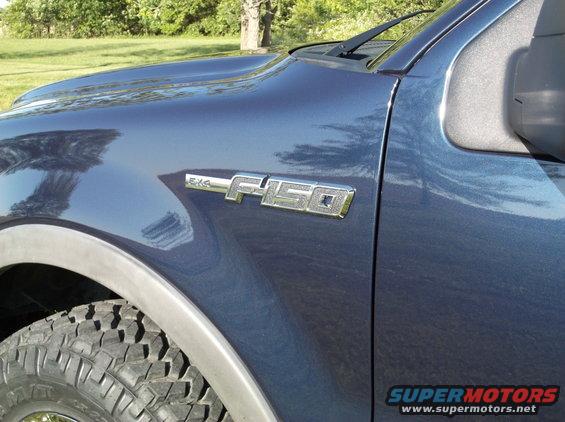 Close-up of F-150 badge on blue truck fender