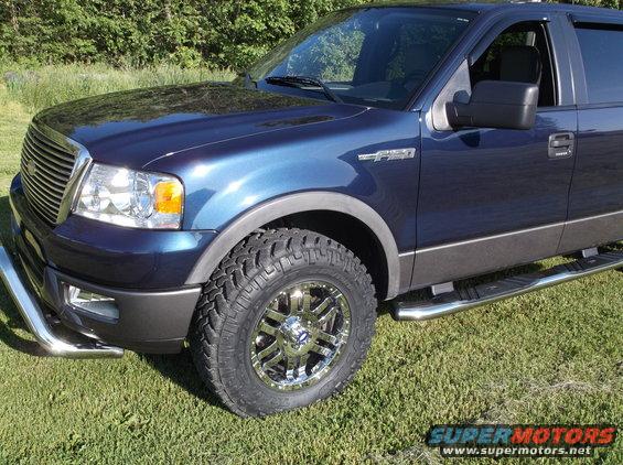 Blue 2005 Ford F-150 truck, front quarter view, chrome wheels, running boards