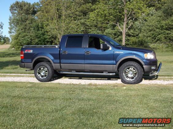 Blue 2005 Ford F-150 truck, side view, with aftermarket wheels and bull bar