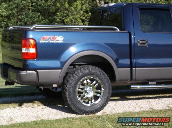 Blue Ford F-150 FX4 Off Road pickup truck, rear quarter view, showing aftermarket wheels