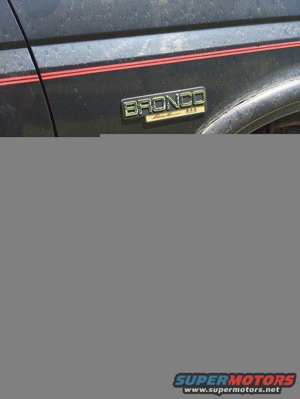 1994 Ford Bronco Eddie Bauer 4x4 emblem on dark body with red stripe