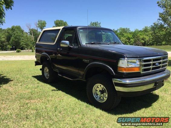 1994 Ford Bronco parked on grass, front 3/4 view