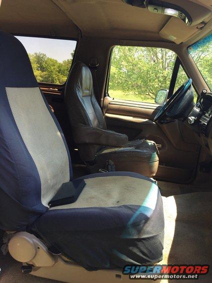 Interior of a 1992 Ford Bronco with worn brown seats and blue seat covers
