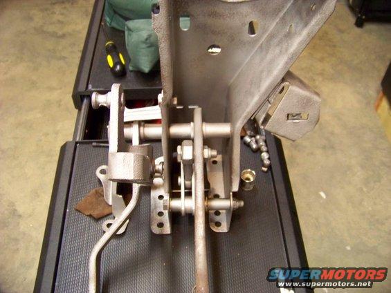 Close-up of a vehicle's clutch and brake pedal assembly, showing linkages and mounting hardware