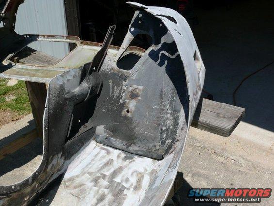 car body panel on sawhorses, looks like it's being prepped for repair