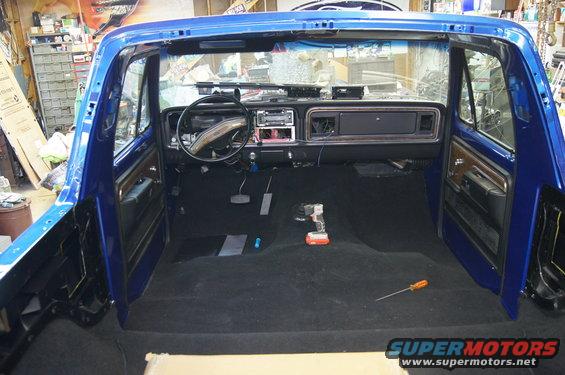 1979 Ford Bronco interior with black carpet and dashboard visible
