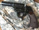 1987 Ford Bronco - A black flare gun with a textured grip is shown from a side angle on a camouflage background.