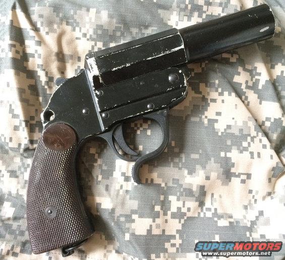 Black flare gun on camouflage background