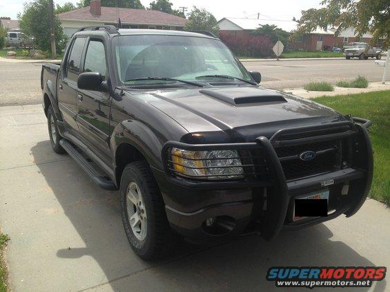 Dark gray Ford Sport Trac with a black bull bar and hood scoop parked on a driveway