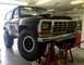 1979 Ford Bronco - 1979 Ford Bronco undergoing maintenance, lifted on jack stands in a garage.