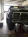 1979 Ford Bronco - Front view of a black 1978 Ford Bronco being worked on in a garage, raised on jack stands.